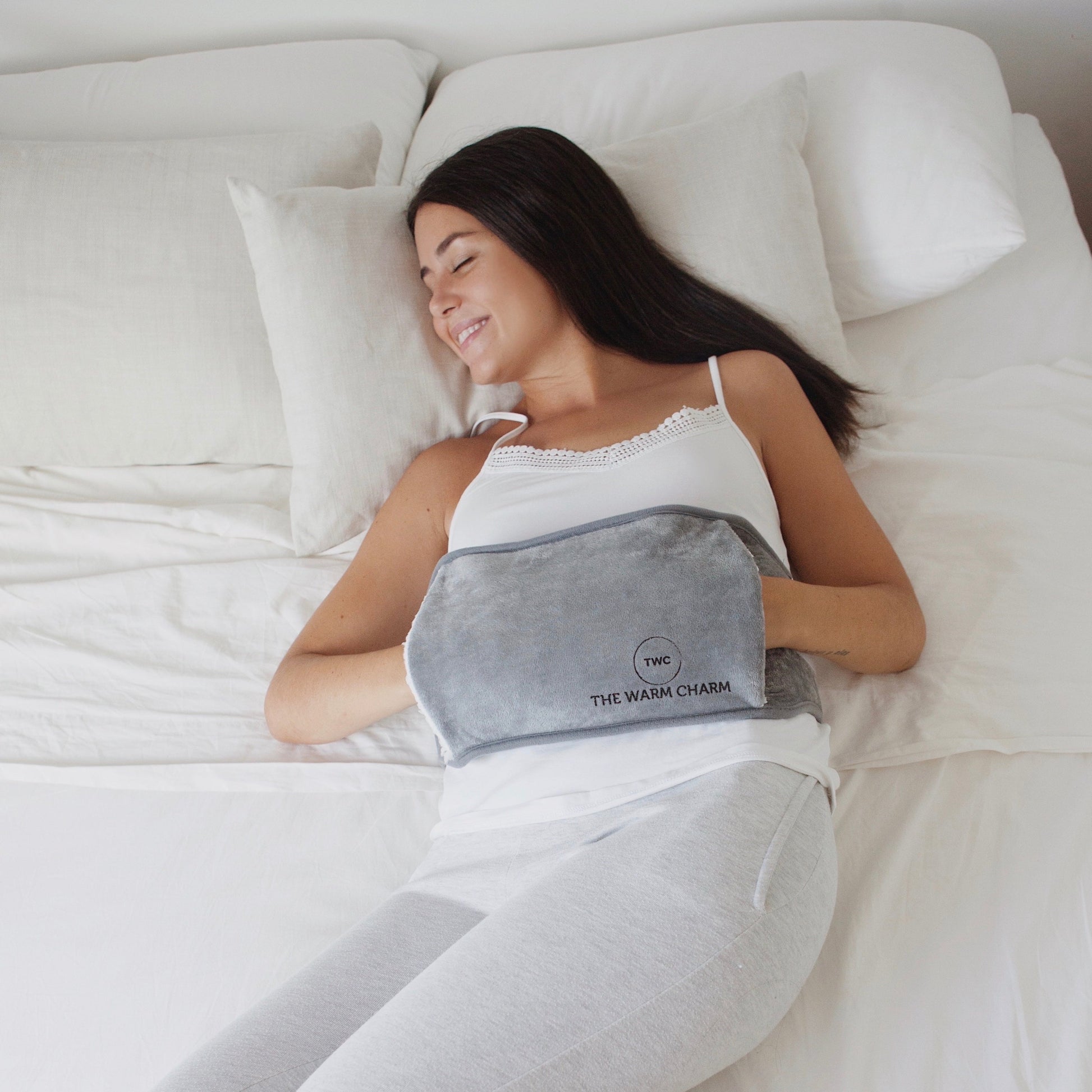 lie in bed with electric heat pack with belt for abdominal pain relief